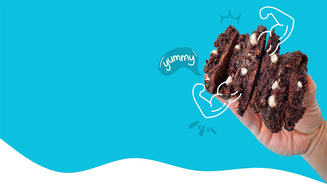 Hand holding Hot Choc It Up Protein Cookies with illustrated flexing arms.