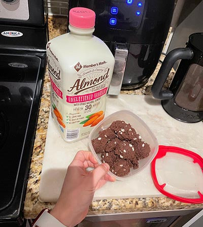 Hot Choc It Up protein cookie dough in container with almond milk